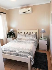 sypialnia z łóżkiem i klimatyzacją w obiekcie Three Palms One Bedroom Apartment - SOLAR w mieście Ballito