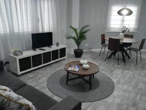 ein Wohnzimmer mit einem Sofa und einem Tisch in der Unterkunft Apartamento AQUAVIVA - El Médano in El Médano