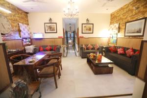 グレーター・ノイダにあるHouse Of Comfort Greater Noidaのリビングルーム(ソファ、テーブル、時計付)
