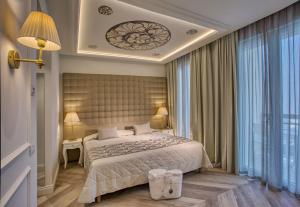 a bedroom with a bed and a large window at Hotel Eliseo Terme in Montegrotto Terme