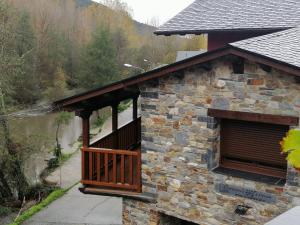 a stone building with a porch and a balcony at Casa Rural Rio Cabrera in Las Médulas