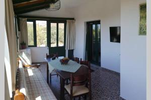 a dining room with a table and chairs and windows at Strofi House in Argoulés