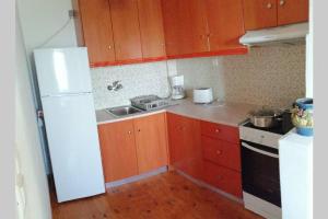 a kitchen with a white refrigerator and a sink at Strofi House in Argoulés +15 photos