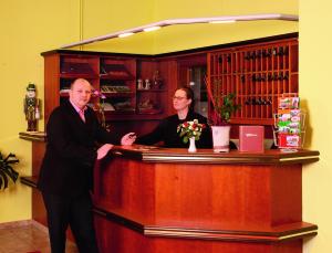 a man and a woman standing at a bar at Hotel Stadt Wittstock in Wittstock