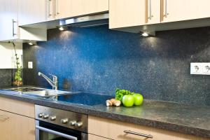 a kitchen with a sink and some apples on the counter at Ferienwohnungen Gästehaus Schraudolf in Oberstdorf +7 photos