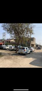 een groep auto's geparkeerd op een parkeerplaats met een boom bij Mufis Homestay, Emerald Compound, New Palam Vihar-2 in Gurgaon