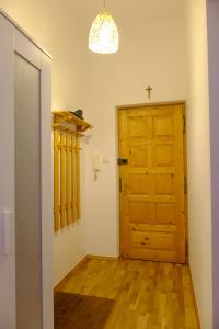 a hallway with a wooden door and a cross on the wall at Blisko miło ładnie Apartament w centrum Zakopanego in Zakopane
