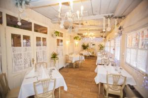 restauracja z białymi stołami, krzesłami i żyrandolami w obiekcie Boutique Hotel Szárcsa w Székesfehérvárze +37 zdjęć
