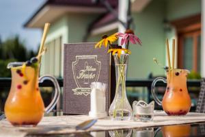 three vases with flowers in them on a table at Hotel Viliam Frano in Nitra