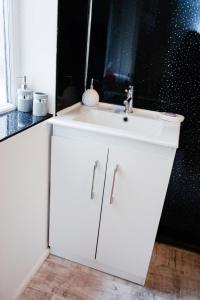 ブラックプールにあるBridle Lodge Apartmentsの白い洗面台と鏡のあるバスルーム