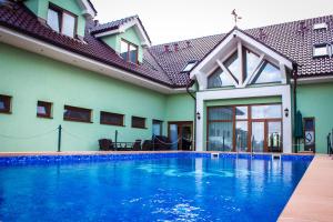 a swimming pool in front of a house at Hotel Viliam Frano in Nitra