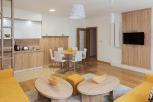 a living room with a table and chairs and a kitchen at Turistic Apartments Centar Sarajevo in Sarajevo