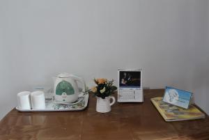a table with a tea set and a tea pot and flowers at Amado Homestay Ella in Ella