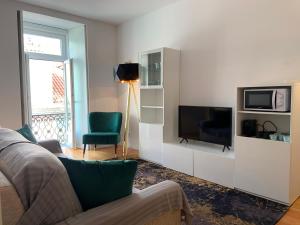 ein Wohnzimmer mit einem Flachbild-TV und einem Sofa in der Unterkunft Baixa Pombalina - Deluxe Modern Apartment in Lissabon