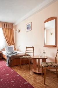 Schlafzimmer mit einem Bett, einem Tisch und einem Spiegel in der Unterkunft Hotel Druzhba in Kiew