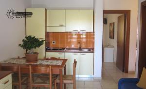 een keuken met witte kasten en een tafel met een wastafel bij Residence Marina di Carlino Tourist in Gallipoli