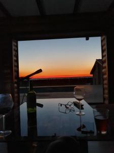 Różaniec的住宿－Dom wakacyjny Różaniec，玻璃桌,带一瓶葡萄酒和两杯