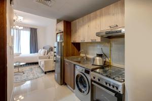 a kitchen with a stove and a washer and dryer at bnbmehomes - Classic Studio Apt in the heart of JVC - 214 in Dubai