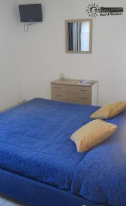 een blauw bed met kussens en een dressoir in een slaapkamer bij Residence Marina di Carlino Tourist in Gallipoli