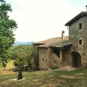 een oud stenen huis in een veld bij Casa Rural El Callís in Vall de Bianya