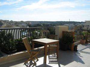 a wooden table and two chairs on a balcony at Apartment in Marsaskala in Marsaskala