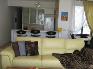 a living room with a yellow couch and a kitchen at Apartment in Marsaskala in Marsaskala