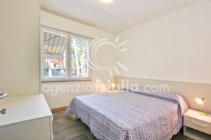sypialnia z łóżkiem i oknem w obiekcie Villa Conchiglia w Lignano Sabbiadoro
