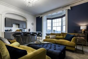 un salon avec des canapés jaunes et une cuisine dans l'établissement Pieces of Eight - 2 Bedroom Apartment - Tenby - (Windsor House), à Tenby