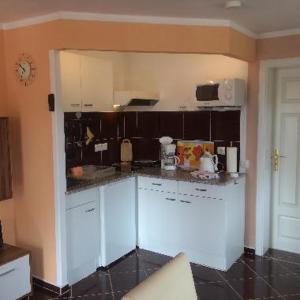 a kitchen with white cabinets and a counter top at Ferienwohnungen Weber in Friedrichsbrunn