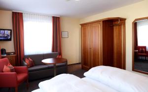 Habitación de hotel con cama y silla en Hotel Warteck en Freudenstadt