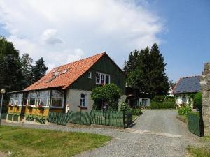 una casa con techo naranja y valla en Ferienwohnungen Weber en Friedrichsbrunn