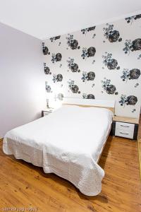 ein Schlafzimmer mit einem Bett mit Blumenwand in der Unterkunft Balázs Szálló in Gyula