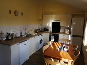 a kitchen with white cabinets and a table and a sink at The Old Stables self catering in Salisbury