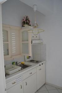 帕爾加的住宿－Dolphin Apartments 2，白色的厨房设有水槽和炉灶。