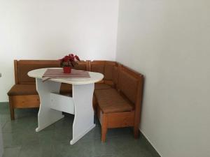 a white table and chair with a vase of flowers on it at Simona in Topliţa
