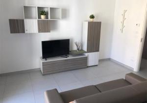 un salon avec une télévision et un canapé dans l'établissement 3G BAROQUE APARTMENTS, à Lecce