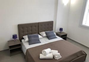une chambre avec un grand lit avec des serviettes dessus dans l'établissement 3G BAROQUE APARTMENTS, à Lecce