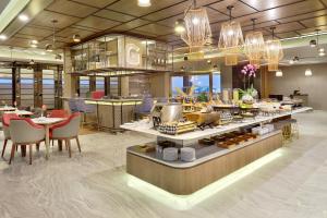 a restaurant with a counter with food on it at Novotel Suites Yogyakarta Malioboro in Yogyakarta