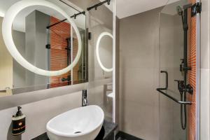 La salle de bains est pourvue d'un lavabo blanc et d'un miroir. dans l'établissement Ginger Goa, Panjim, à Panaji