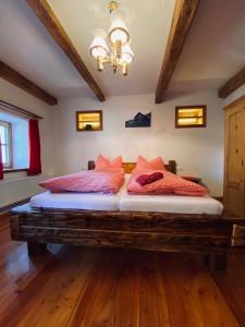 a bedroom with a large bed with red pillows at Lerchnerhof in Eisentratten