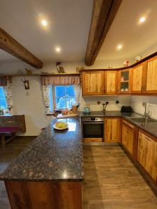 a kitchen with wooden cabinets and a black counter top at Lerchnerhof in Eisentratten