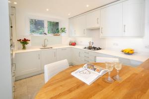 a kitchen with a wooden table and white cabinets at High Barn, Ambleside in Ambleside