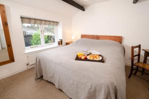 a bedroom with a bed with a tray of fruit on it at High Barn, Ambleside in Ambleside