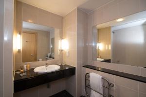 a bathroom with two sinks and a mirror at Regency Park Hotel, Health Club & Spa in Newbury