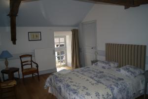 1 dormitorio con 1 cama, 1 silla y 1 ventana en Château de Fontnoble, en Biozat