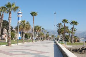 トレ・デル・マールにあるMagnifico ático en la playaの椰子の木と灯台のある通り