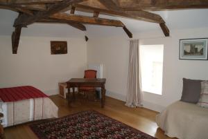 a bedroom with a desk and a bed and a window at Château de Fontnoble in Biozat
