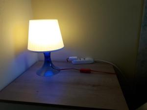 a blue lamp sitting on a table with a cord plugged into it at La Casa Nel Verde 2 in Bologna