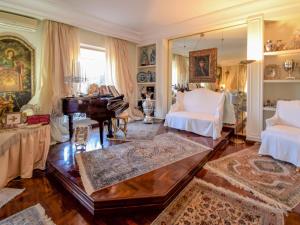 un soggiorno con pianoforte e mobili bianchi di Apartment Giardino delle Palme by Interhome a Palermo