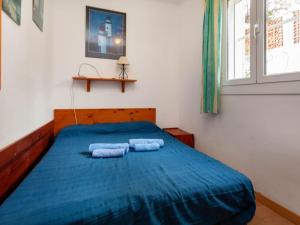 a bedroom with a blue bed with two towels on it at Holiday Home Villa Cassiopee by Interhome in Llança
